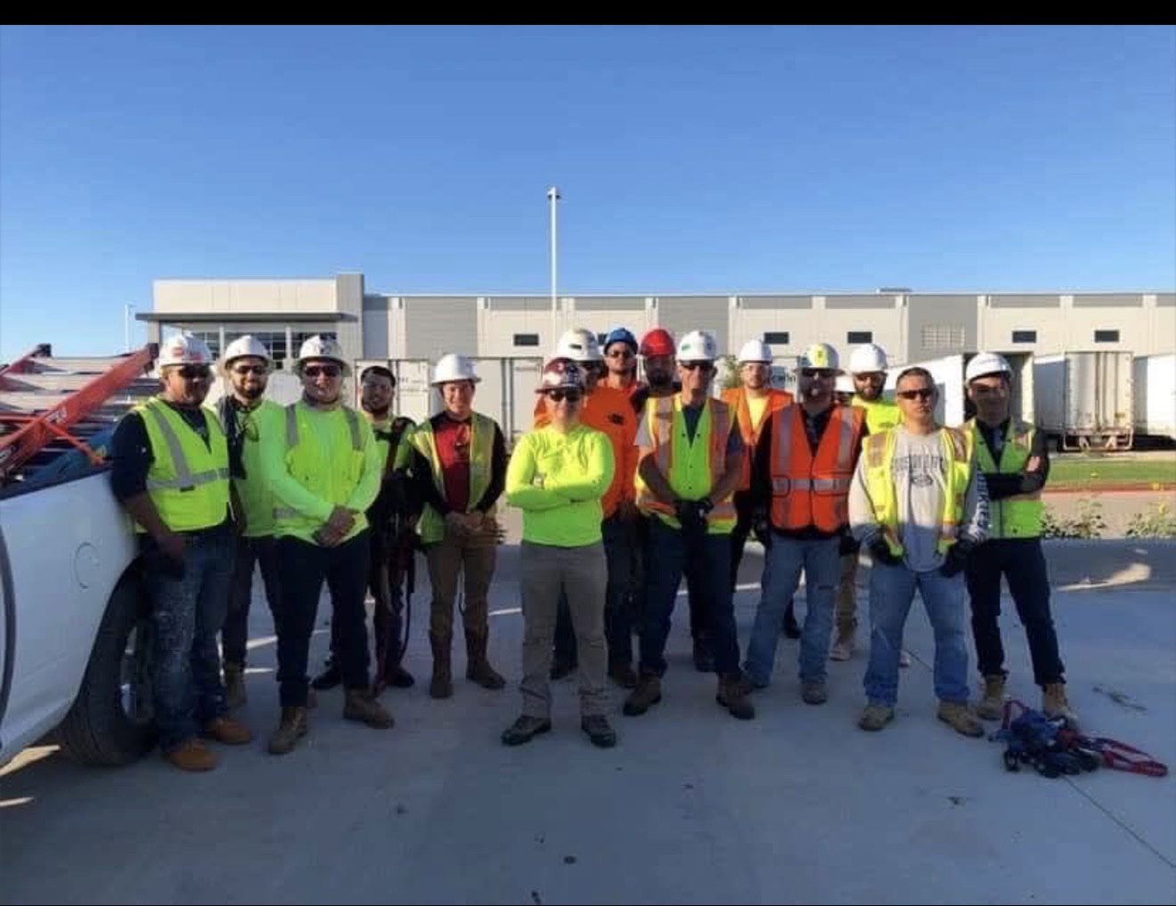 Supreme Glaziers Inc crew on site — 14 glaziers in hard hats and safety vests